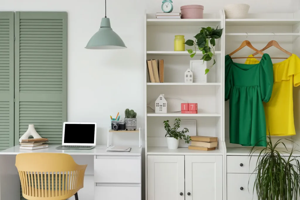 closet plus office set up with clothes hanging and desk with laptop