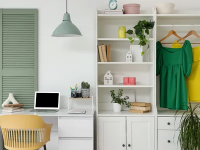 closet plus office set up with clothes hanging and desk with laptop